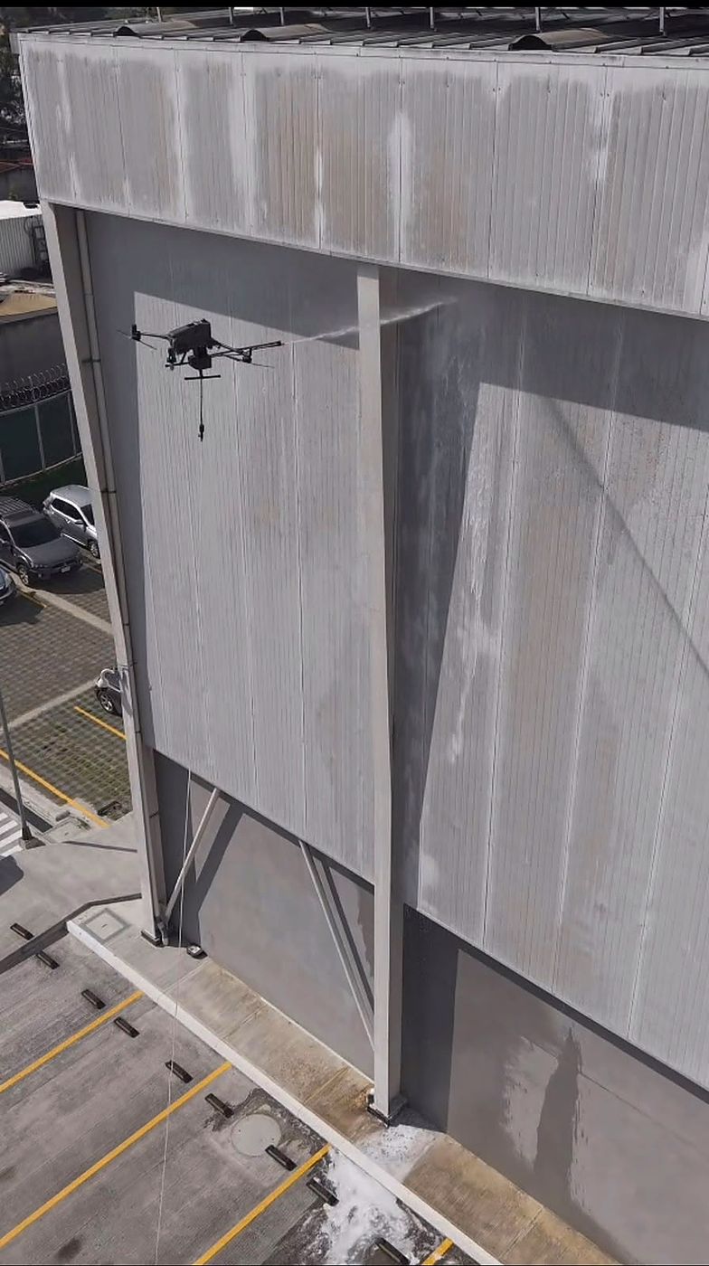 Dron de VERTIKA lavando la fachada de una galera industrial